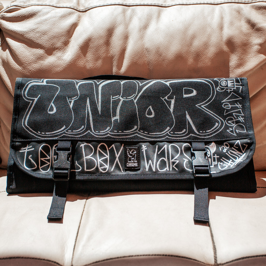 Chrome x Squid Unior tool roll giveaway prize, black canvas roll with white graffiti Unior Toolbox Wars artwork