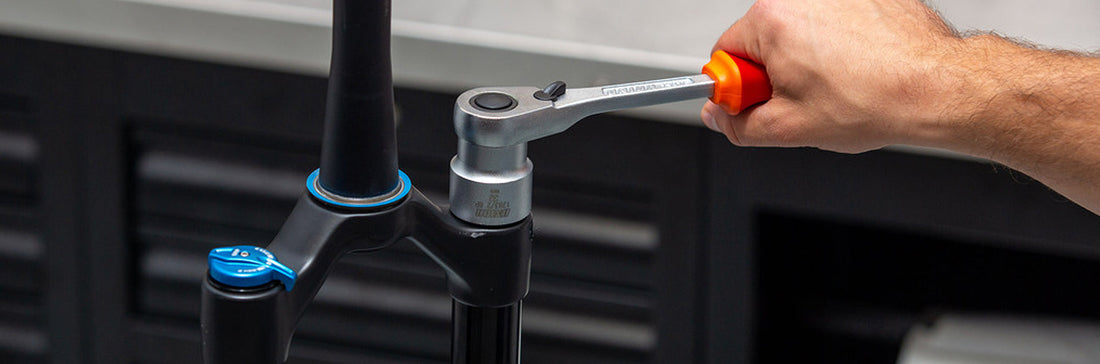 Mechanic servicing a suspension fork's lower legs in a Unior-equipped workshop