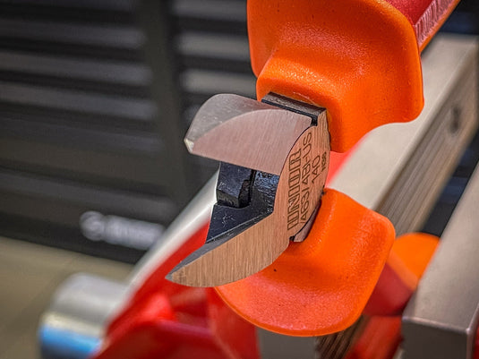 Cutting a zip tie cleanly with Unior flush cutters at a workshop bench
