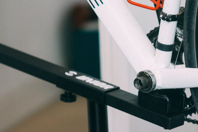 White hardtail mountain bike clamped in a Unior workstand by the seatpost, ready for Hollowtech II bottom bracket service