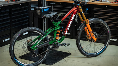Trek downhill bike in a professional bike workshop lined with black Unior tool cabinets and workbenches