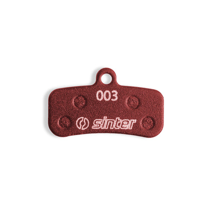 Sinter Red 003 disc brake pad back plate close-up, four damping pads around 003 model stamp for Shimano Saint Zee