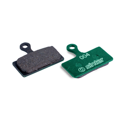 Sinter Green s004 organic disc brake pad next to worn black pad, for Shimano XTR, XT and SLX G/L Type calipers