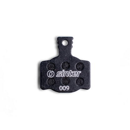 Sinter Model 009 Black disc brake pad backplate close-up, dimpled friction texture and 009 model stamp visible