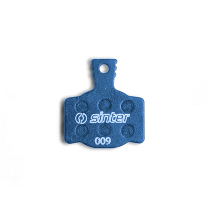 Sinter Model 009 Blue disc brake pad backplate close-up, dimpled friction texture and 009 model stamp visible