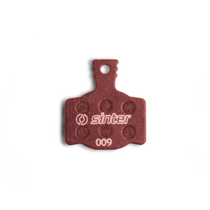 Sinter Model 009 Red disc brake pad backplate close-up, dimpled friction texture and 009 model stamp visible