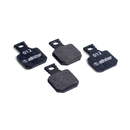 Sinter Model 012 Magura black organic brake pads, four pads showing black backplates stamped 012 and dark friction material