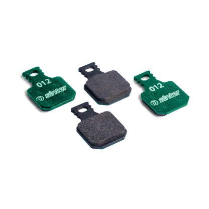 Sinter Model 012 Magura green organic brake pads, four pads showing green backplates stamped 012 and dark friction surfaces