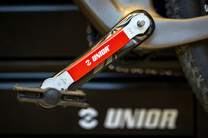 Unior 3-in-1 Pedal Wrench engaging 8 mm hex on a mountain bike crank arm, Unior toolbox in background