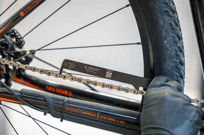 Gloved mechanic checking chain stretch with the Chain Wear Indicator 1644/6 on a Trek mountain bike drivetrain