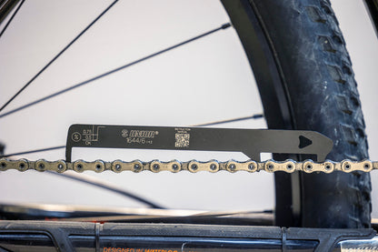 Unior Chain Wear Indicator 1644/6 laid across a chain at the rear wheel, scale markings facing the camera