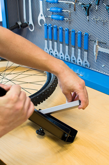 Unior Portable Truing Stand 1688, pulling the hidden support foot out of the base for free-standing use