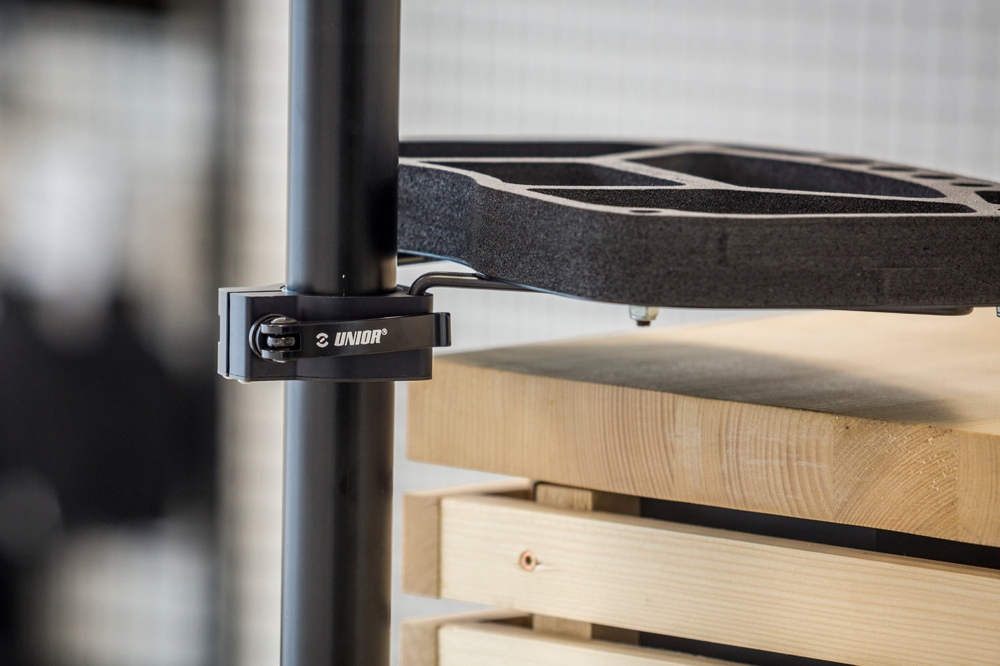 Unior Repair Stand Tool Tray Collar 1693.16 in use - quick-release collar clamped on the stand's upper tube, carrying the tool tray's support arms