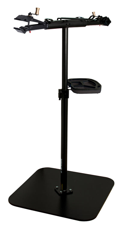Unior double-arm professional repair stand in black, two quick-release clamp heads on a crossbar above a tool tray