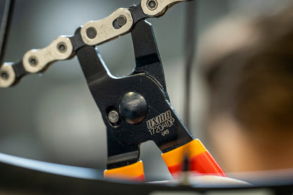 Unior Master Link Pliers 1720/4DP engaging a chain master link on a wheel, jaw tips seated on the link pins