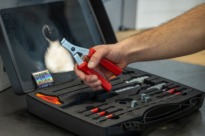 Mechanic using red-handled spoke tension pliers from the Master Wheel Building Kit 1754, open case on bench
