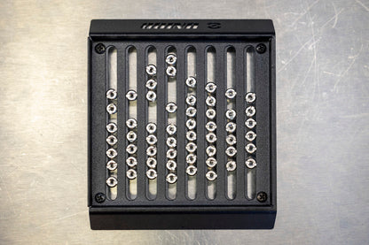 Unior Spoke Nipple Shuffler 1761 after a shake, silver spoke nipples lined up in the laser-cut grid slots