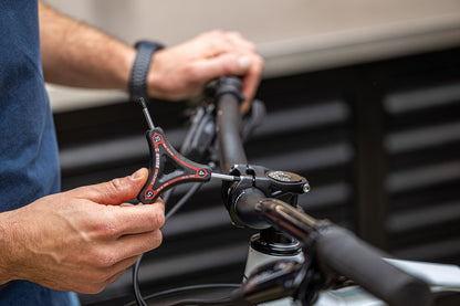 Mechanic using Unior Y Hex & Torx wrench TX25 arm on a mountain bicycle stem bolt at the handlebar