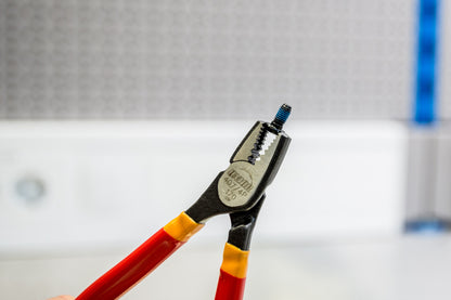 Unior 407/4DP-US screw grabbing pliers gripping a small setscrew by its head, serrated jaws clamped on the outer diameter