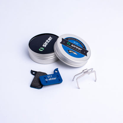 Sinter Blue 017 organic brake pads with stainless spring clip and aluminum storage tin, SRAM road fit