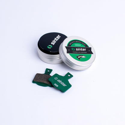 Sinter Model 009 Green organic disc brake pad pair beside aluminium tin packaging for Magura hydraulic calipers