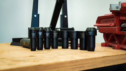 Unior 1702 fork seal driver bundle, black socket drivers in graduated sizes lined up on a workshop bench with vise