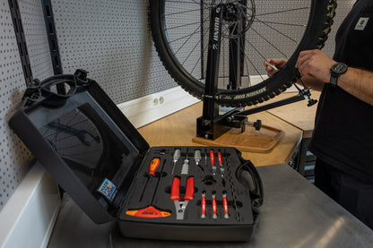 Master Wheel Building Kit 1754 open on a bench beside a wheel in a Unior truing stand; the stand is not part of the kit