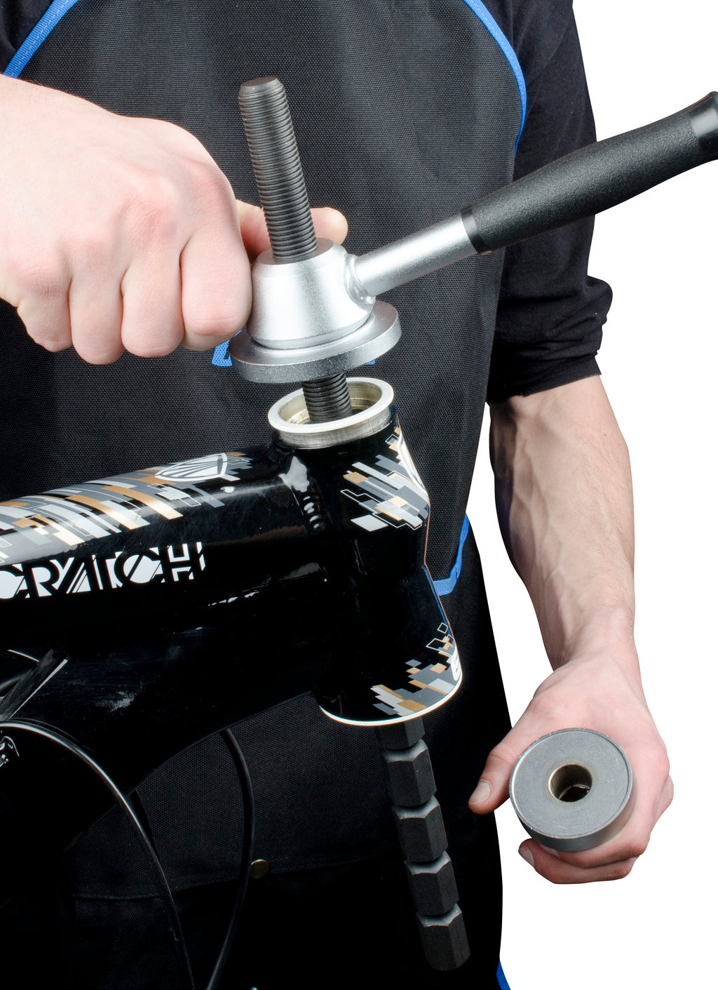 Unior Headset Press 1680/4 seating a headset cup in a head tube; T-handle flange on the cup, stepped spindle through the bore, clamping sleeve in the mechanic's other hand
