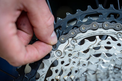 Pressing the last link of the Unior 1658/2P gauge chain toward the sprocket to read tooth wear