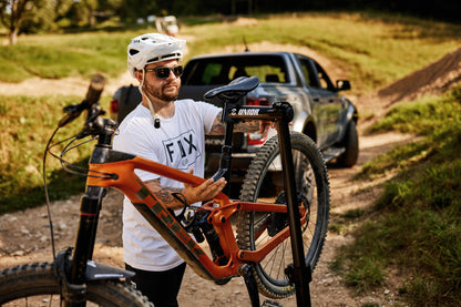 Unior BikeGator+ 1693A-US in use: mechanic clamping a mountain-bike seatpost in the auto-adjusting jaw
