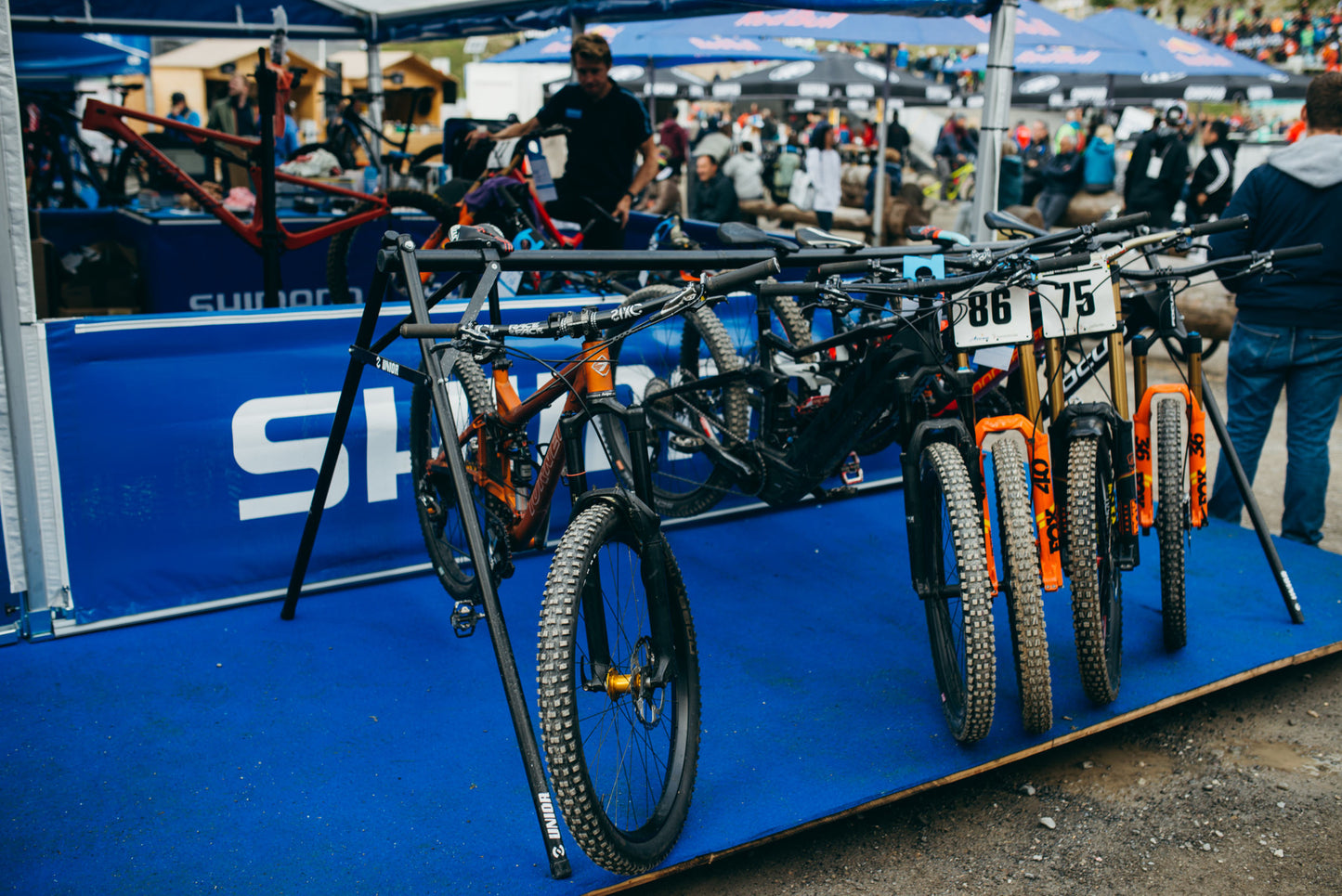 Unior Event Stand 1693F in a race-event paddock with numbered mountain bikes queued for service