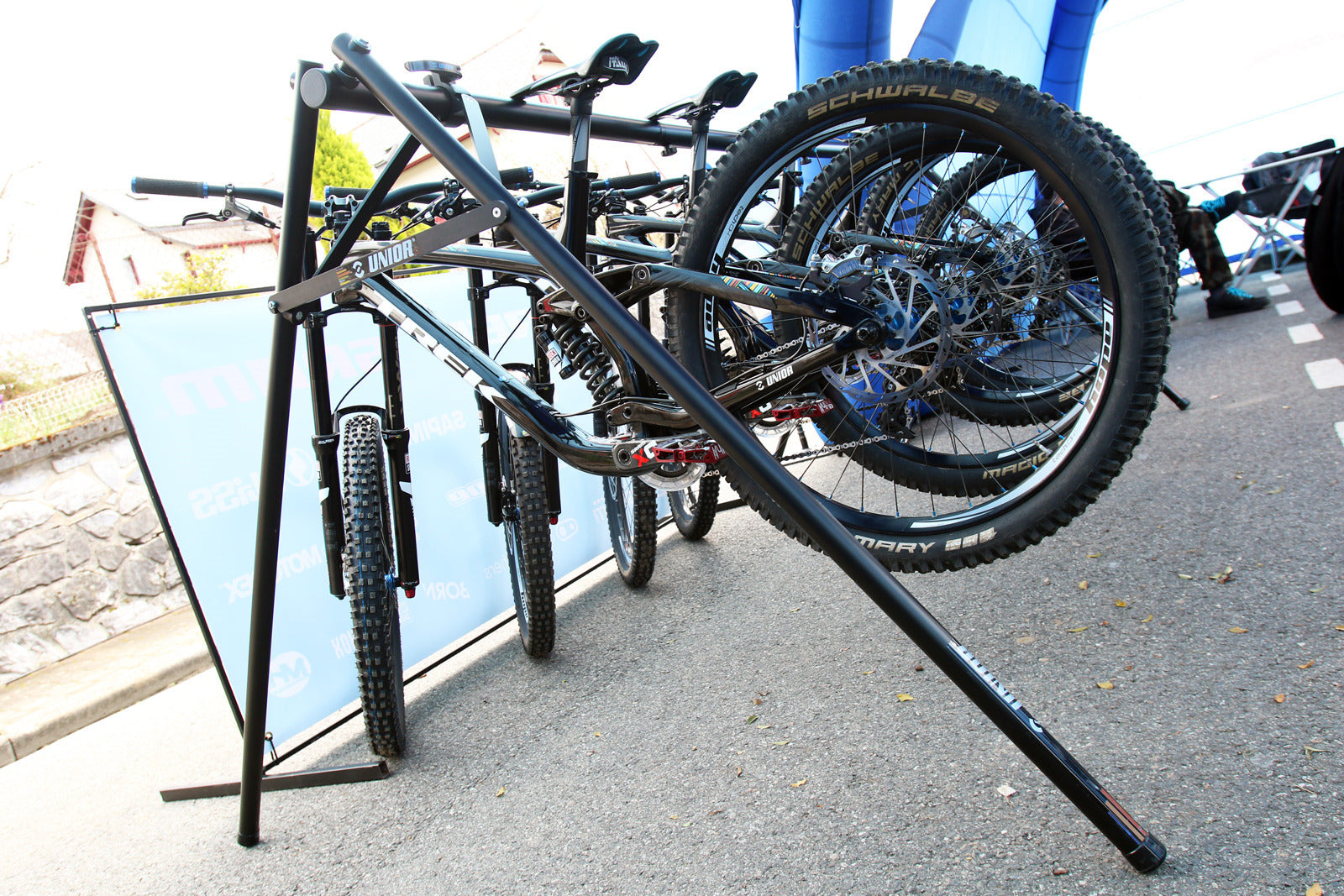 Unior Event Stand 1693F holding downhill bikes hung by their saddles at an outdoor race venue