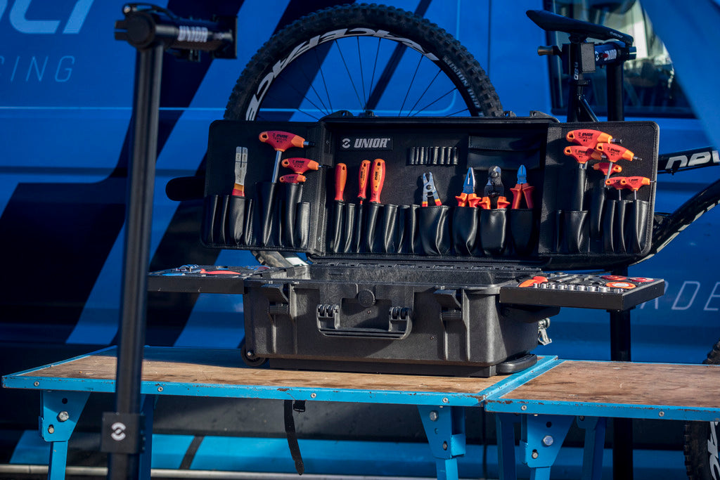 Unior Master Tool Kit 1600MASTERKIT-US open on a paddock bench, 94-piece US-red bicycle workshop kit in the wheeled composite case