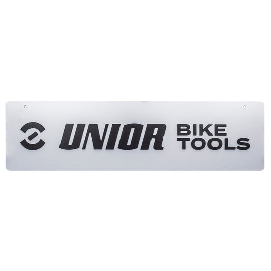 Unior logo panel, front view: silver-gray sign with black Unior symbol, UNIOR BIKE TOOLS lettering and two mounting holes