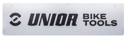 Unior Bike Tools logo panel PANEL1, silver-gray sign with black Unior symbol and lettering, two mounting holes at the top