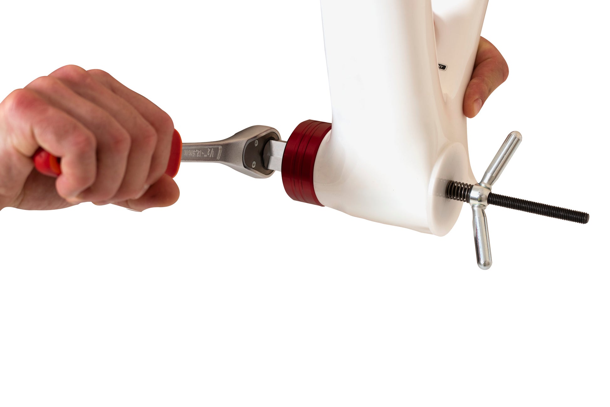 Unior 1671.RET socket retaining tool in use: 1/2 inch ratchet turning a red aluminum BB socket on a dummy shell, spring rod and T-handle through the spindle bore