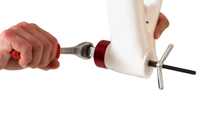 Unior 1671.RET socket retaining tool in use: 1/2 inch ratchet turning a red aluminum BB socket on a dummy shell, spring rod and T-handle through the spindle bore