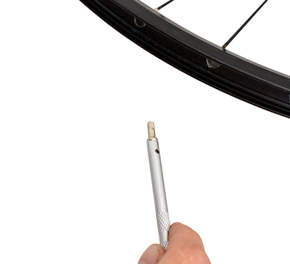 Unior 1751/2Q square nipple driver held toward a rim from the tire side, showing the square tip
