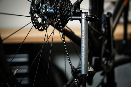 Unior Hanger Genie aligning a rear derailleur hanger on a bicycle drivetrain, cassette and chain in view