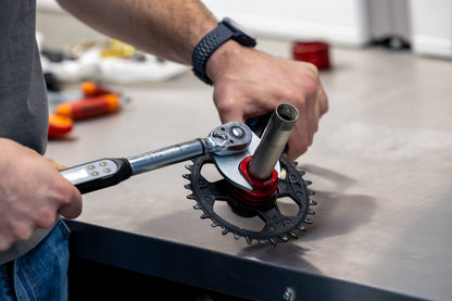 Mechanic using a Unior digital torque wrench with Crowfoot 1725/2CF adapter to set a chainring lockring on a mountain bike crank