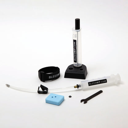 Bleedkit Premium Shimano bleed kit components arranged on a workshop bench with overflow reservoir and syringe