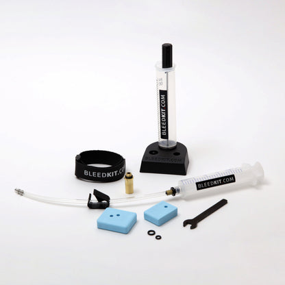 Bleedkit Premium Road Shimano bleed kit components on a workshop bench, overflow reservoir and syringe