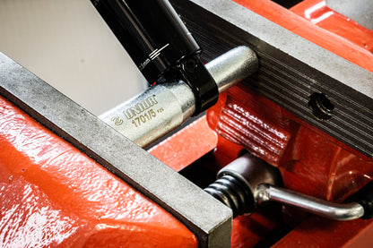Unior 1701/5 bushing extractor pressing a bushing out of a mountain bike rear shock eyelet in a shop press