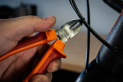 Mechanic trimming a brake cable end on a road bicycle with Unior 461 diagonal side cutters