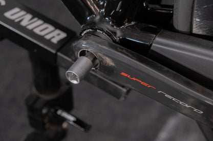 Unior hex bit socket engaging a Campagnolo Super Record crankset bolt, bicycle mounted on a Unior workstand