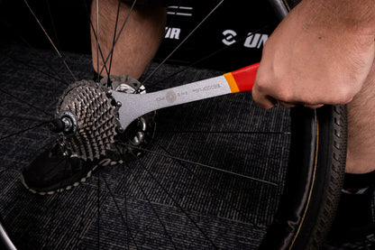 Mechanic holding Unior Multispeed Chainwhip 1660/2DP-US engaged on a rear cassette during sprocket removal
