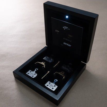 Sinter Elite presentation box open with internal LED light, Hayes Dominion A4 brake pad sets in gold and silver finishes inside