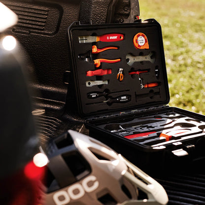 Unior Home Kit hard case open in a pickup truck bed beside a POC mountain bike helmet, grass background